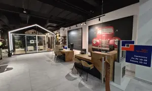 Nowoczesny salon okien i drzwi z ekspozycją, grafiką czerwonego auta i ladą sprzedażową.