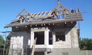 Na dachu budowanego domu widoczna jest drewniana wiecha.