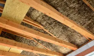 Drewniana konstrukcja dachu z wełną mineralną i płytą OSB.