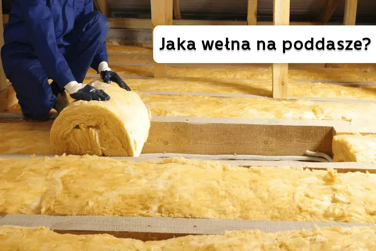 Ocieplanie poddasza wełną mineralną. Pracownik układa rolkę izolacji między drewnianymi belkami.