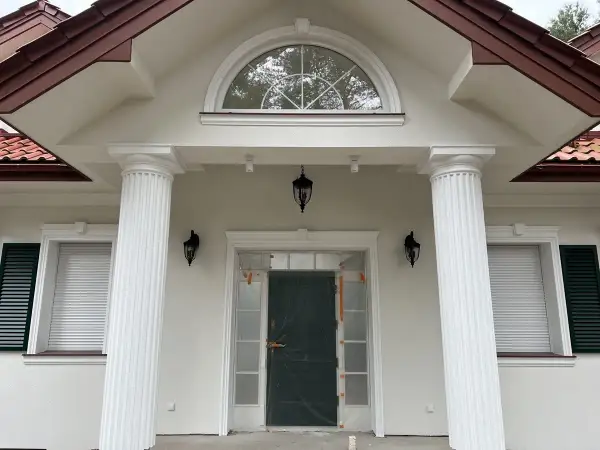 Elegancki pilaster zdobi fasadę domu, wspierając dach nad wejściem.