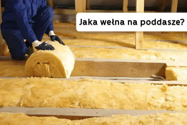 Ocieplanie poddasza wełną mineralną. Pracownik układa rolkę izolacji między drewnianymi belkami.